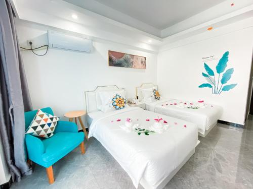 a bedroom with two beds and a blue chair at Bohol Dolphin Bay Resort in Panglao