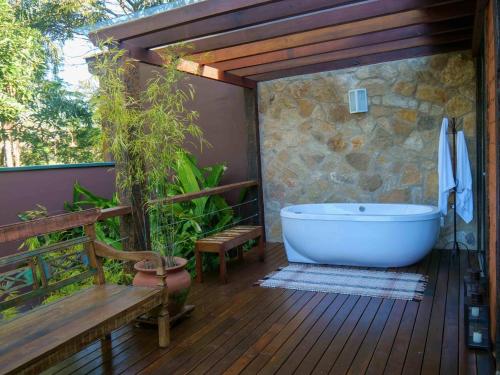 蒂拉登蒂斯的住宿－Lofts Villa da Serra，带浴缸的浴室,位于带长凳的甲板上