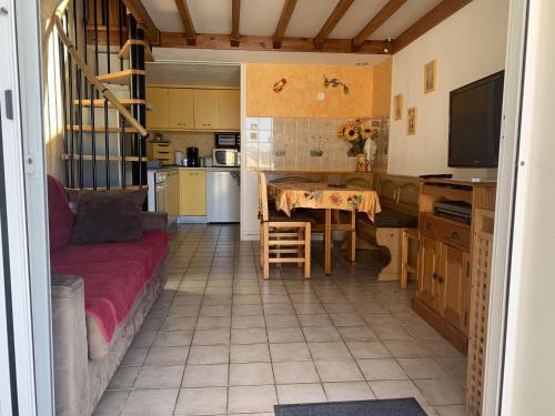 - une cuisine avec un canapé et une table dans une chambre dans l'établissement Maison 6P - Lac Marin, à Port-Leucate