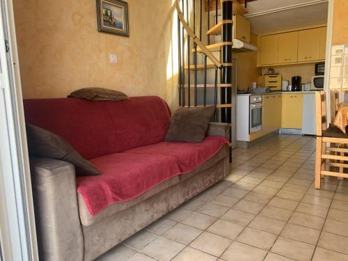 un salon avec un canapé rouge dans une cuisine dans l'établissement Maison 6P - Lac Marin, à Port-Leucate