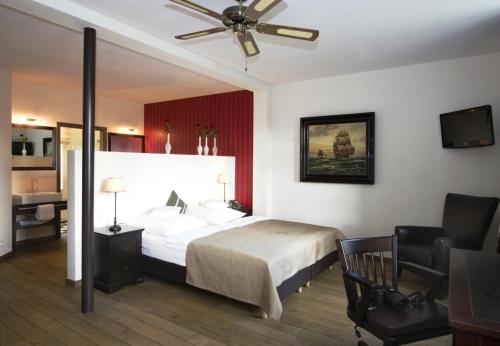 a bedroom with a bed and a ceiling fan at Hotel & Restaurant Grenzhof in Heidelberg