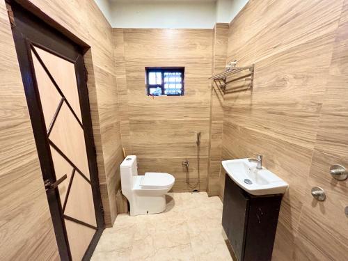 a bathroom with a toilet and a sink at Pet Friendly Cottage Room in Kolkata in Kolkata