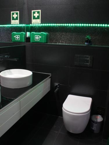 łazienka z toaletą, umywalką i zielonym światłem w obiekcie Casa da Dona Palmira w Fatimie