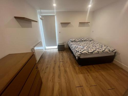 a bedroom with a bed and a wooden floor at SW - Four - 3 in London