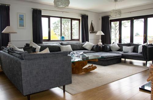 a living room with a couch and a table at Hewas Water House - Private Pool, Hot Tub & Games Room in Grampound