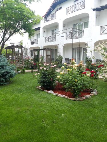 a garden in front of a white building with flowers at Casa Royal Haveli in Costinesti