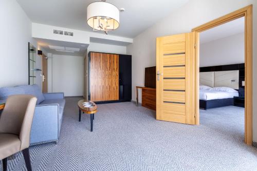 a room with a bedroom with a bed and a sliding door at Diune Hotel by Zdrojowa in Kołobrzeg