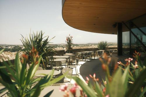 a restaurant with tables and chairs and plants at Hôtel La Prison in Béziers