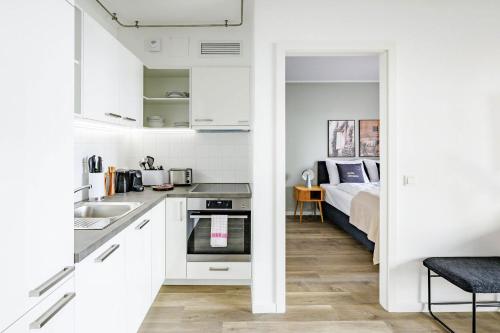 uma cozinha com um lavatório e uma cama num quarto em limehome Budapest Mosonyi u em Budapeste