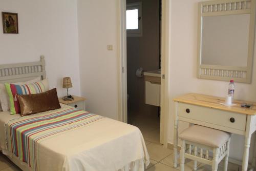 a bedroom with a bed and a desk and a mirror at Hotel Dar Al Madina in Mahdia