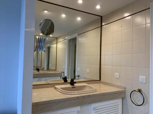 a bathroom with a sink and a large mirror at Illa de tambo house in San Salvador de Poio