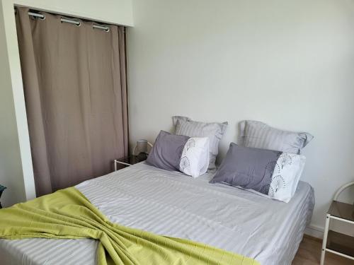 een slaapkamer met een bed met paarse en witte kussens bij Le Clos Saujonnais 2 in Saujon