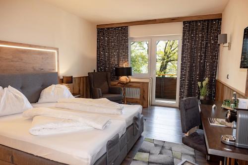 Schlafzimmer mit einem Bett, einem Schreibtisch und einem Fenster in der Unterkunft Hotel Attersee in Seewalchen