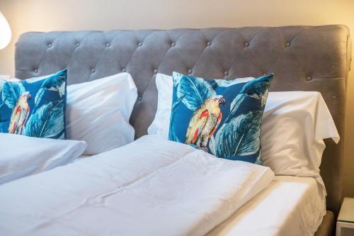 two pillows with birds on them sitting on a bed at Loft Lauben in Bressanone