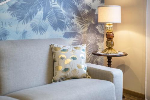 a lamp sitting next to a couch with a pillow at Loft Lauben in Bressanone