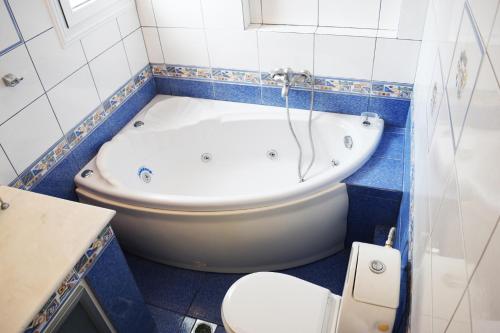 a bathroom with a white tub and a toilet at Aegean Dreams Villa Palio in Paleo Tsifliki