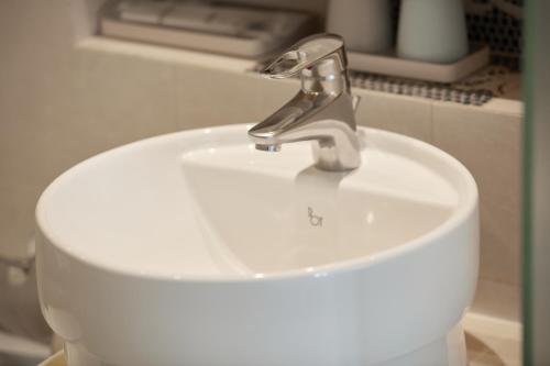 a white sink with a faucet in a bathroom at Ole Tai Sam Un Hotel in Macau