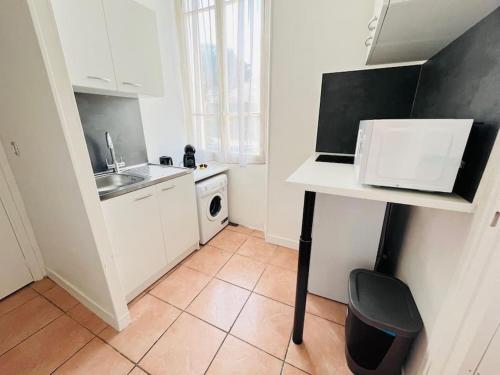une petite cuisine avec un évier et un micro-ondes dans l'établissement Studio centre Golfe Juan, à Vallauris
