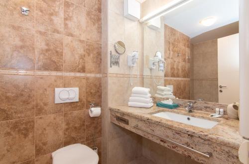 a bathroom with a toilet and a sink and a mirror at Residence Marina Garbin Apartment in Portorož