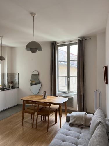 un salon avec une table et un canapé dans l'établissement Maison Lumière - Appart. T2 architecte intra-muros, à Avignon