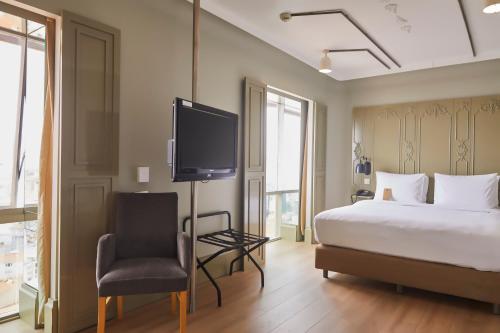 a bedroom with a bed and a tv and a chair at The Cettia Istanbul in Istanbul
