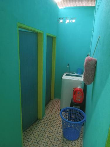 uma pequena casa de banho com uma parede azul e verde em ROSMA HOMESTAY em Kampong Ru Sepuloh