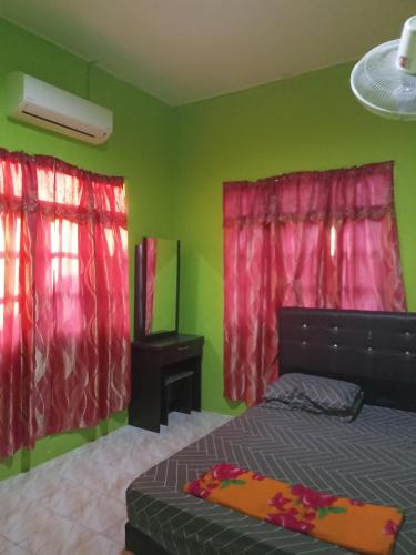 um quarto com uma cama e duas cortinas vermelhas em ROSMA HOMESTAY em Kampong Ru Sepuloh