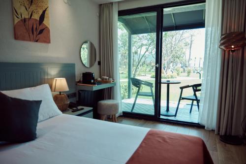 1 dormitorio con 1 cama y balcón con mesa en Parmos Otel, en Erdek