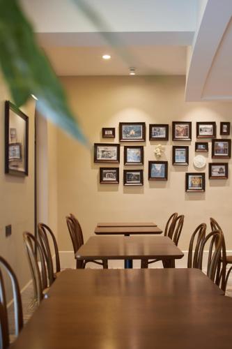 a dining room with tables and chairs and pictures on the wall at Ole Tai Sam Un Hotel in Macau