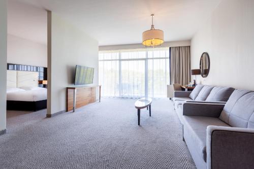 a living room with a couch and a bed at Diune Hotel by Zdrojowa in Kołobrzeg