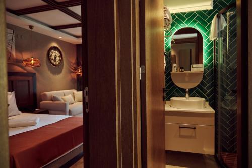 a bedroom with a bed and a sink and a mirror at Parmos Otel in Erdek