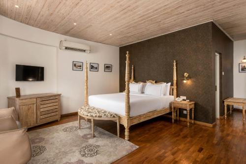 a bedroom with a large white bed and a tv at Ru Boutique in Kandy