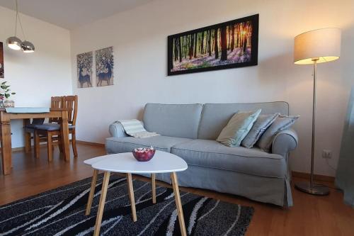 a living room with a couch and a table at Black Forest Schwarzwaldliebe Pool Sauna Tennis Tischtennis Wifi Netflix Natur in Obertal