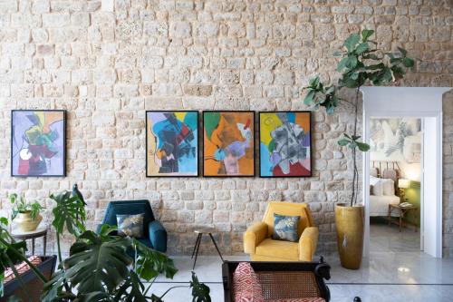 a living room with four paintings on a brick wall at Dar Alice in Soûr