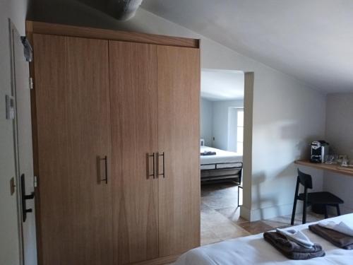 a bedroom with a large wooden cabinet next to a bed at Hotel La Bastide d'Eygalières in Eygalières