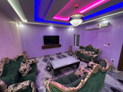 a purple room with couches and a table and a tv at Hotel Yog Safari, Behind Parmarth Niketan in Rishīkesh