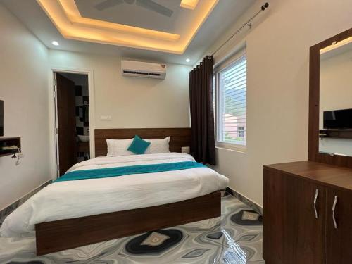 una camera con un grande letto e uno specchio di Hotel Yog Safari a Rishikesh