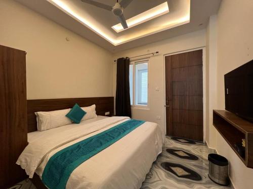 a bedroom with a large bed and a television at Hotel Yog Safari, Behind Parmarth Niketan in Rishīkesh