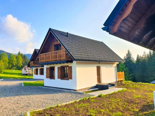 a small house with a wooden roof on a road at Wierchy Beskidu in Dobra