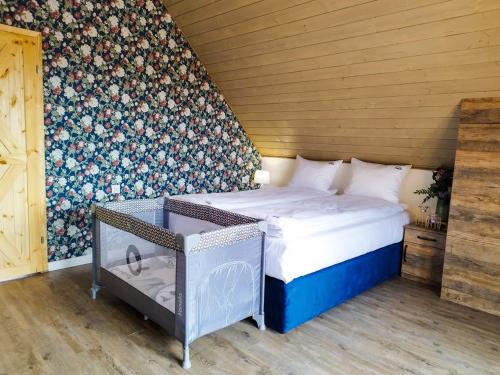 a bedroom with a bed and a wall with flowers at Wierchy Beskidu in Dobra