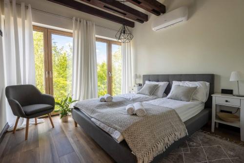 - une chambre avec un lit, une chaise et des fenêtres dans l'établissement Cisza Spokój - Mazury, 