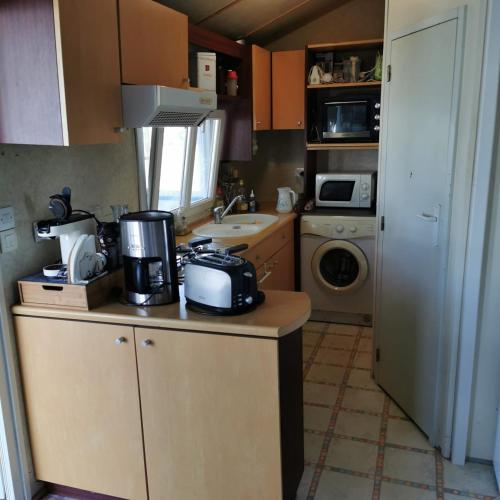 una pequeña cocina con fregadero y microondas en Parc étang de besse, en Saint-Hilaire-de-Riez