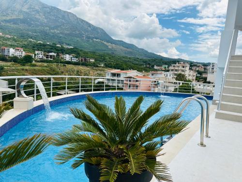 a swimming pool with a palm tree on a balcony at Apartmani Sunce in Bar