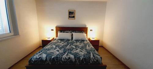 sypialnia z łóżkiem i 2 szafkami nocnymi w obiekcie Casa vacanze Gli Ulivi w mieście Sarzana