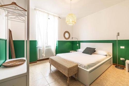 ein Schlafzimmer mit grünen und weißen Wänden und einem Bett in der Unterkunft Teatro Ariston, Elegante Appartamento Centrale in Sanremo
