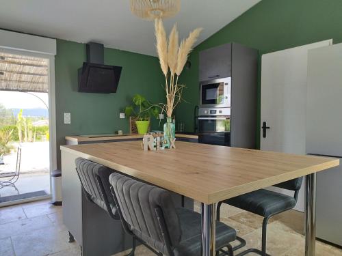 une cuisine avec une table et des chaises en bois dans l'établissement Domaine de l'Arbre Doré, à Lèzan
