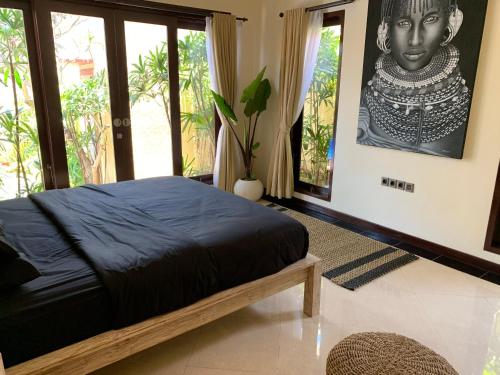 a bedroom with a bed with a picture of a statue at Villa Olga in Seminyak