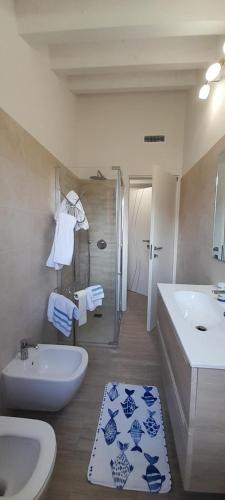 een badkamer met een wastafel, een bad, een toilet en een douche bij Casa vacanze Gli Ulivi in Sarzana