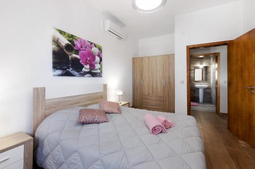 a bedroom with a large white bed with pink pillows at Casa Arinto in Palmela