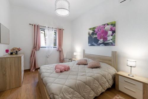 1 dormitorio con 1 cama con 2 almohadas rosas en Casa Arinto, en Palmela
